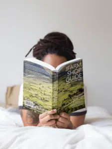 Girl with dreadlocks reading The Farm Shop Guide