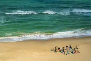 Image of people doing yoga on the beach, by Nick Fewings