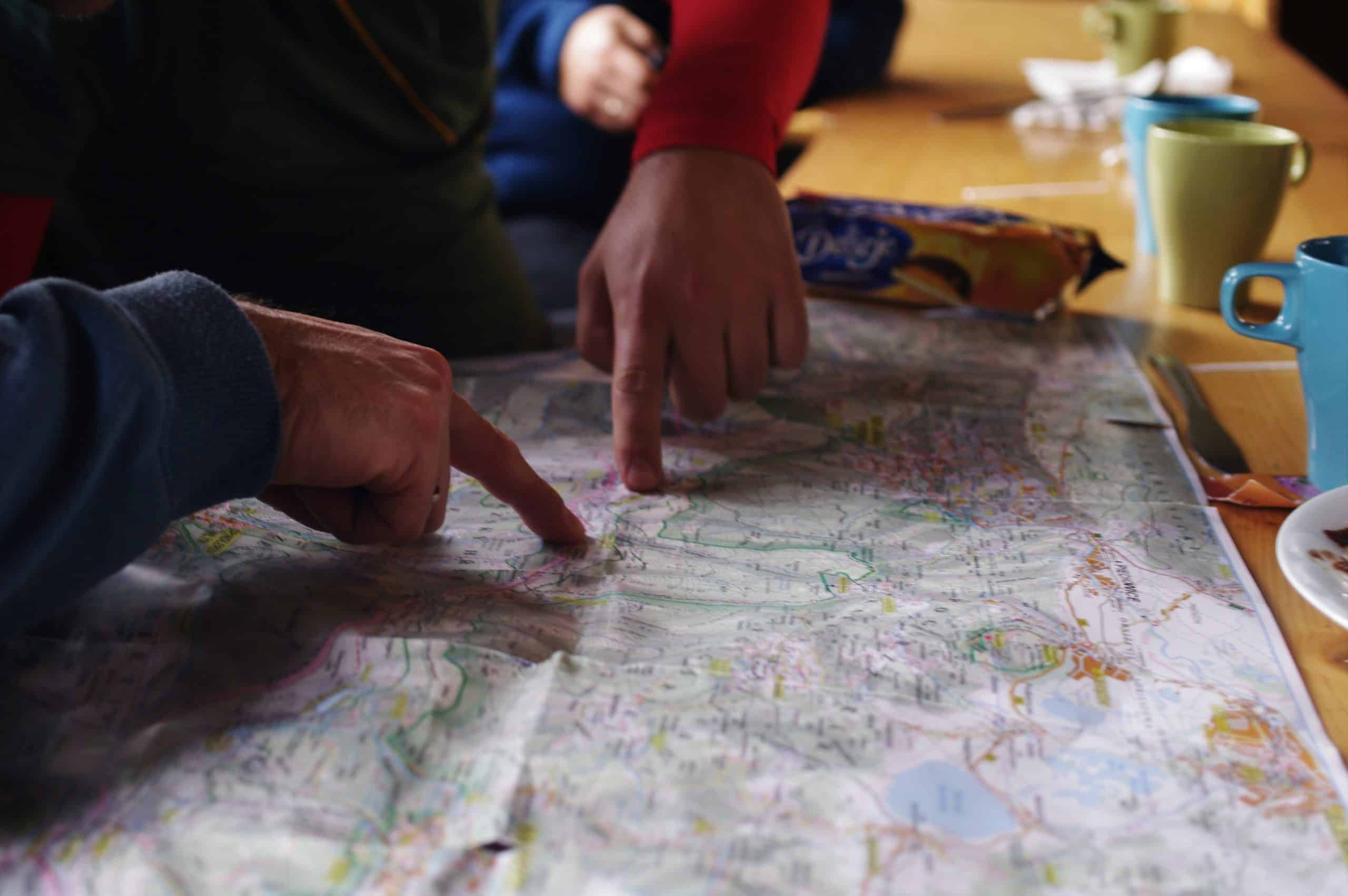 Fingers pointing at a map on a table